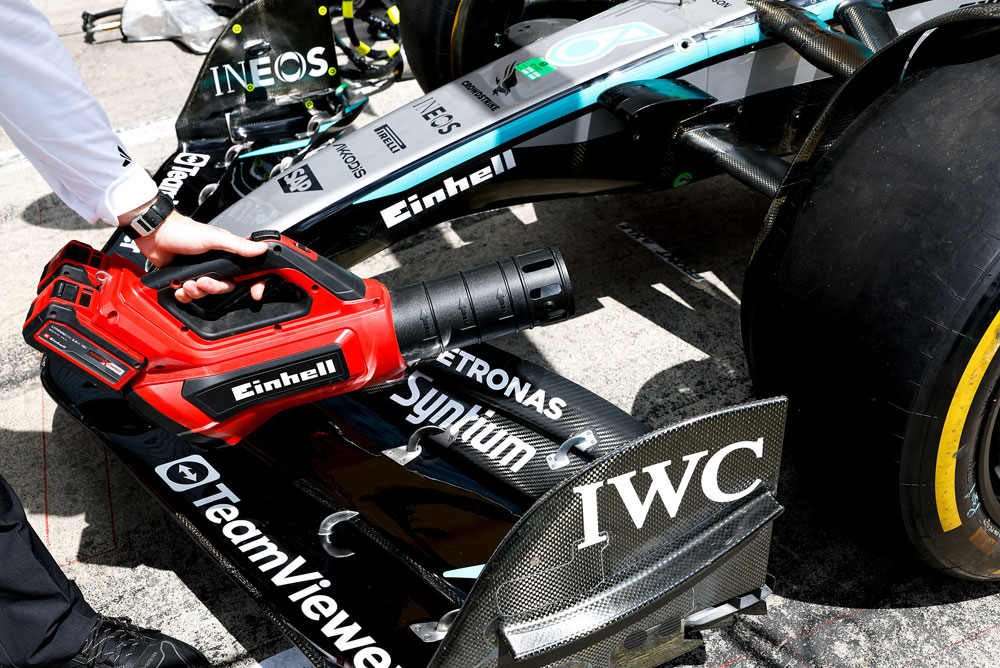 Einhell leaf blower aimed at the front wing of a Formula 1 car.
