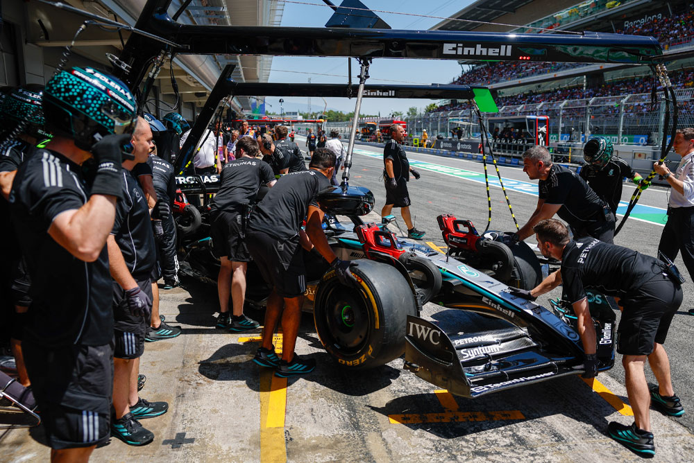 Formula 1 car getting pushed into the garage.