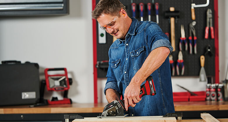 a man cuts a wooden plank