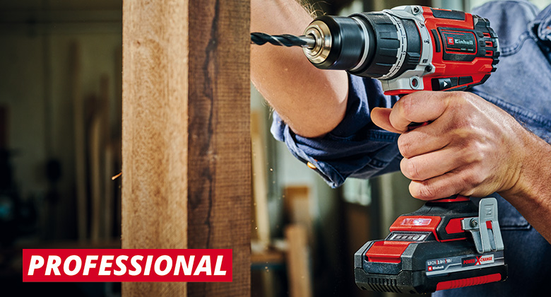 a man drills a hole in the wood with a drill